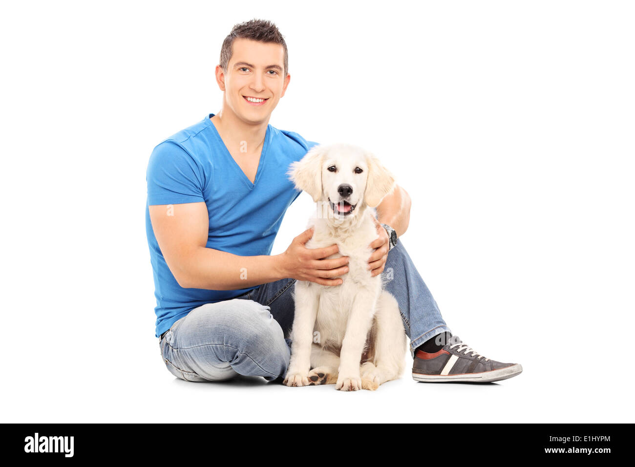 Junger Mann mit seinem Hund auf dem Boden sitzend Stockfoto