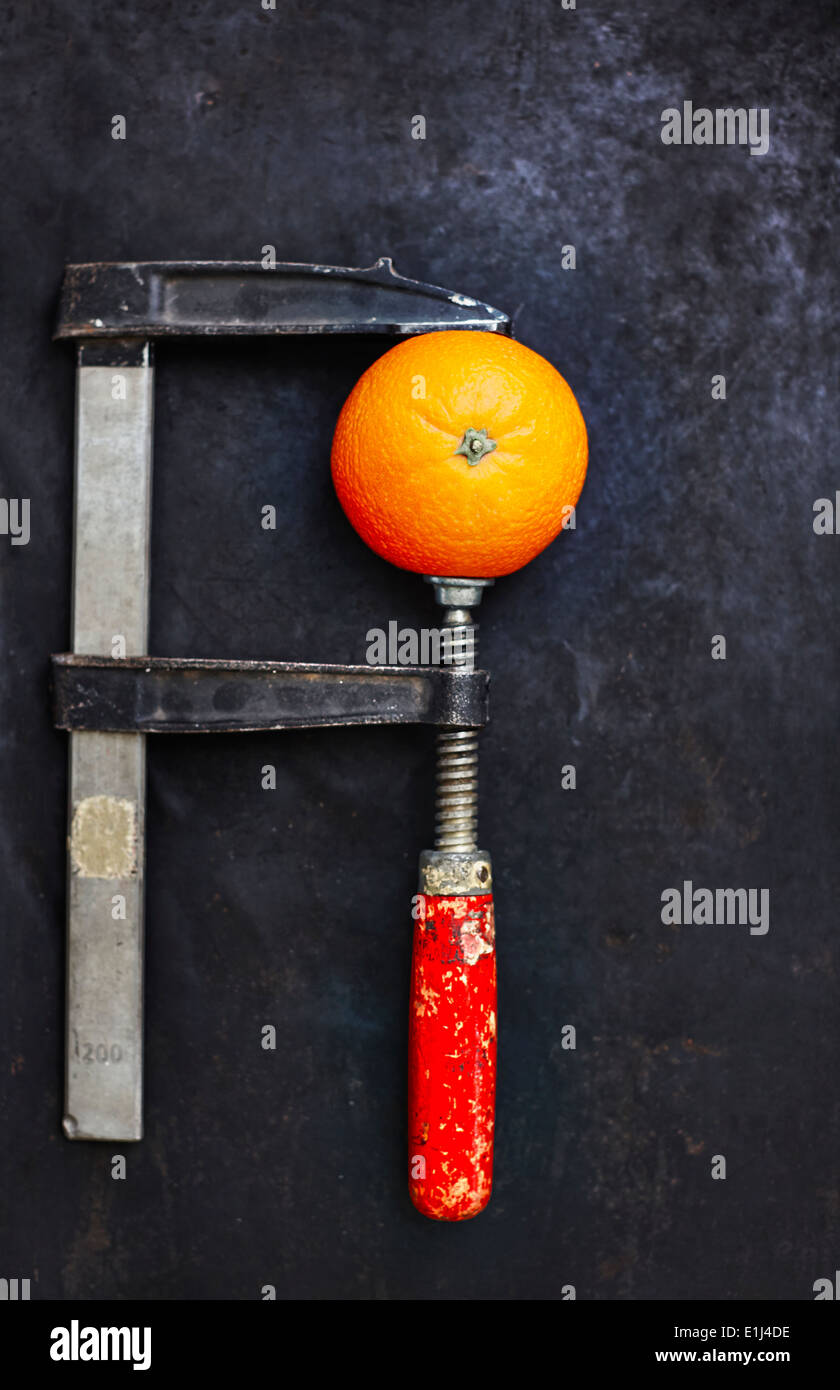 Orange im Schraubstock auf dunklen Grund behoben Stockfoto