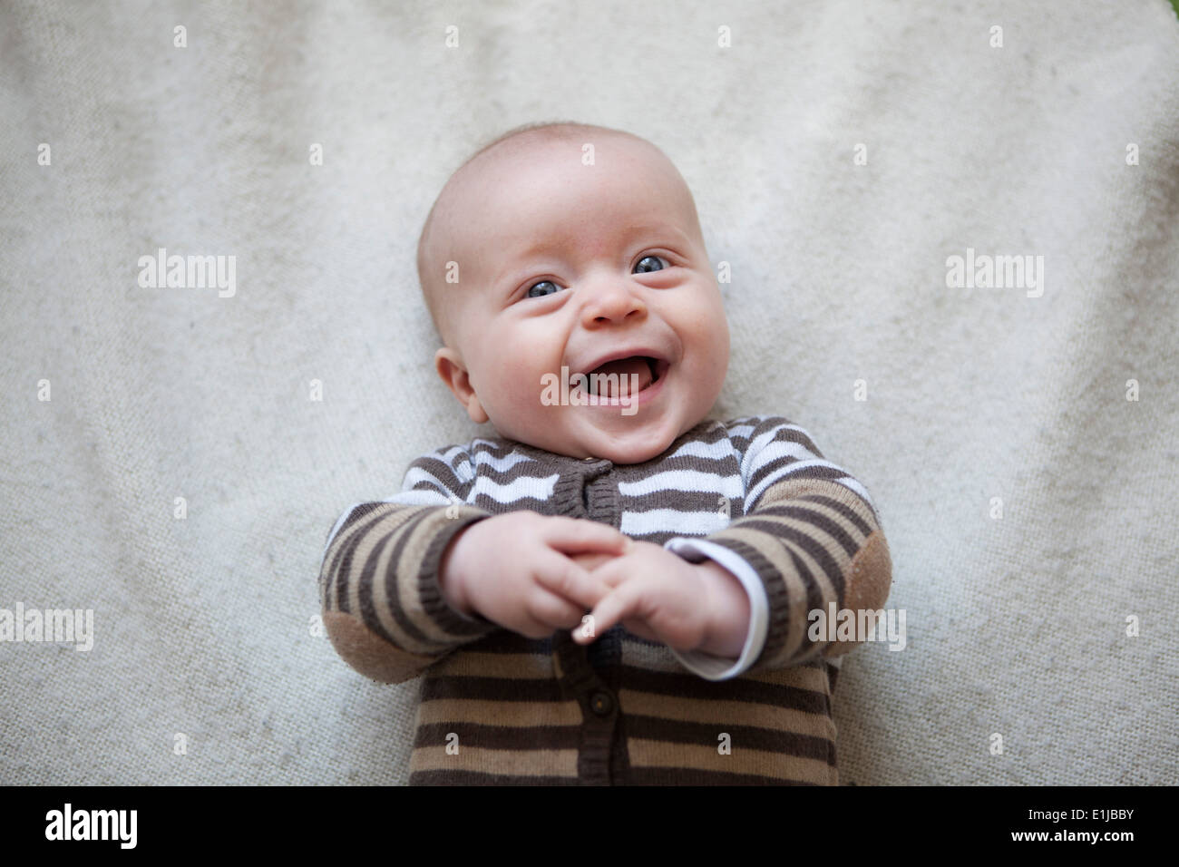 Porträt des Lachens Babyjungen auf Decke liegend, Ansicht von oben Stockfoto