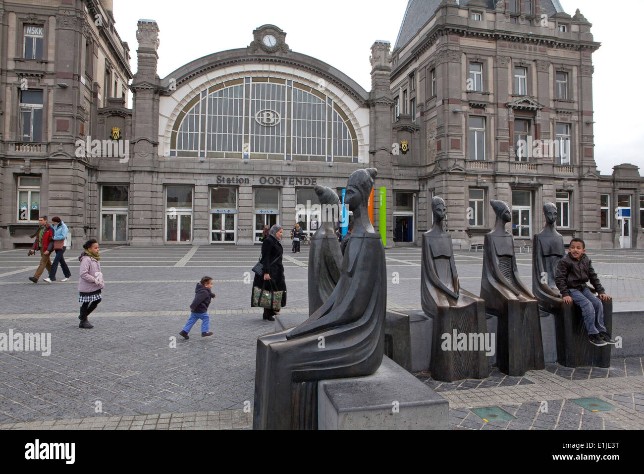 Junge sitzt auf Skulpturen außerhalb Bahnhof Ostende, Belgien Stockfoto