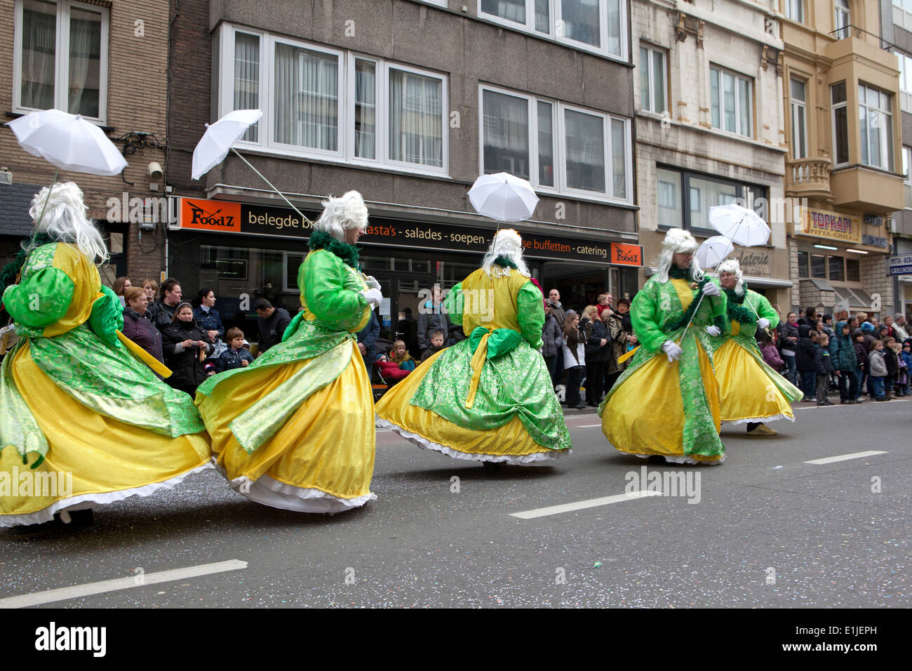 Paradieren Tänzer in lange Kleider mit Sonnenschirmen, Karneval in Ostende, Belgien Stockfoto