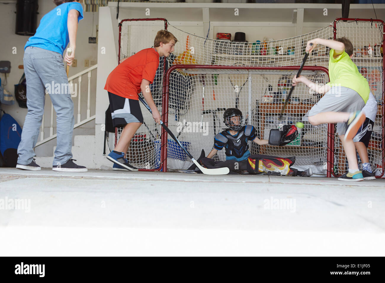 Jungs spielen Eishockey in garage Stockfoto