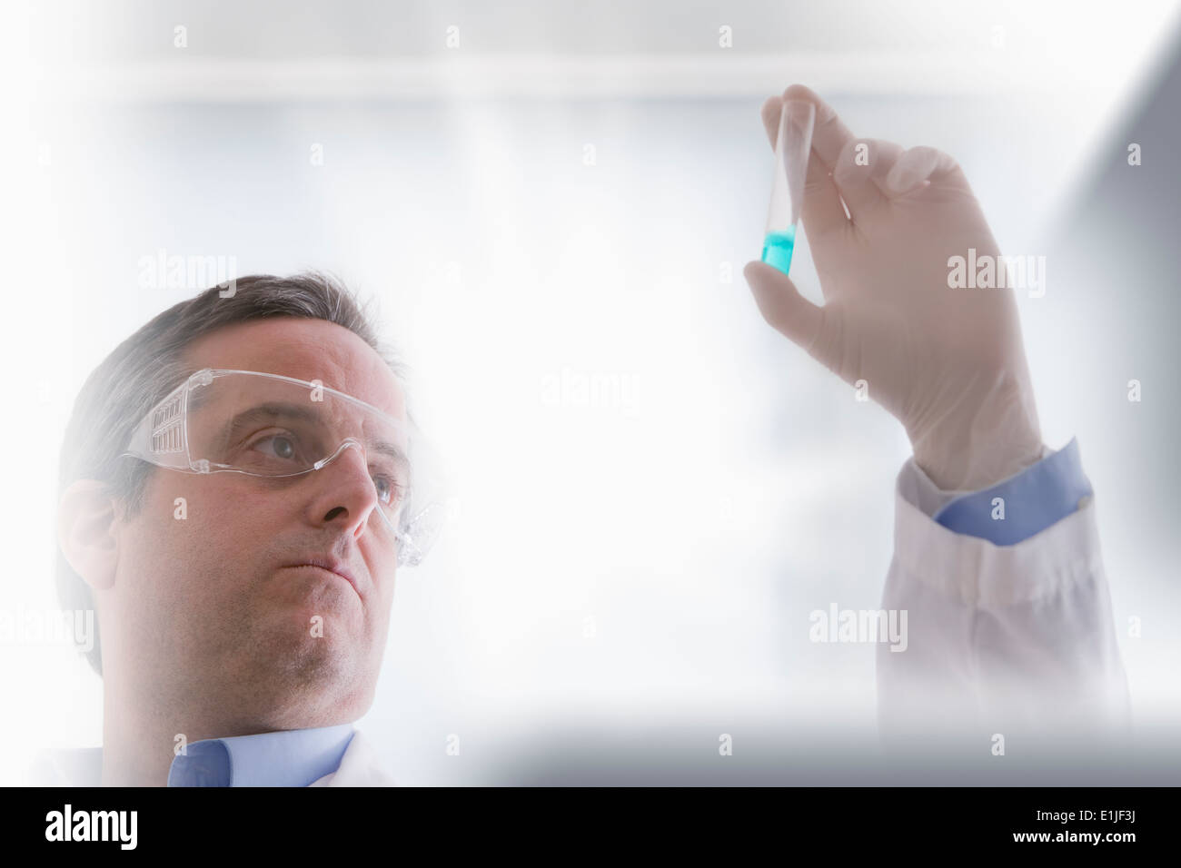 Wissenschaftler betrachten Reagenzglas Stockfoto