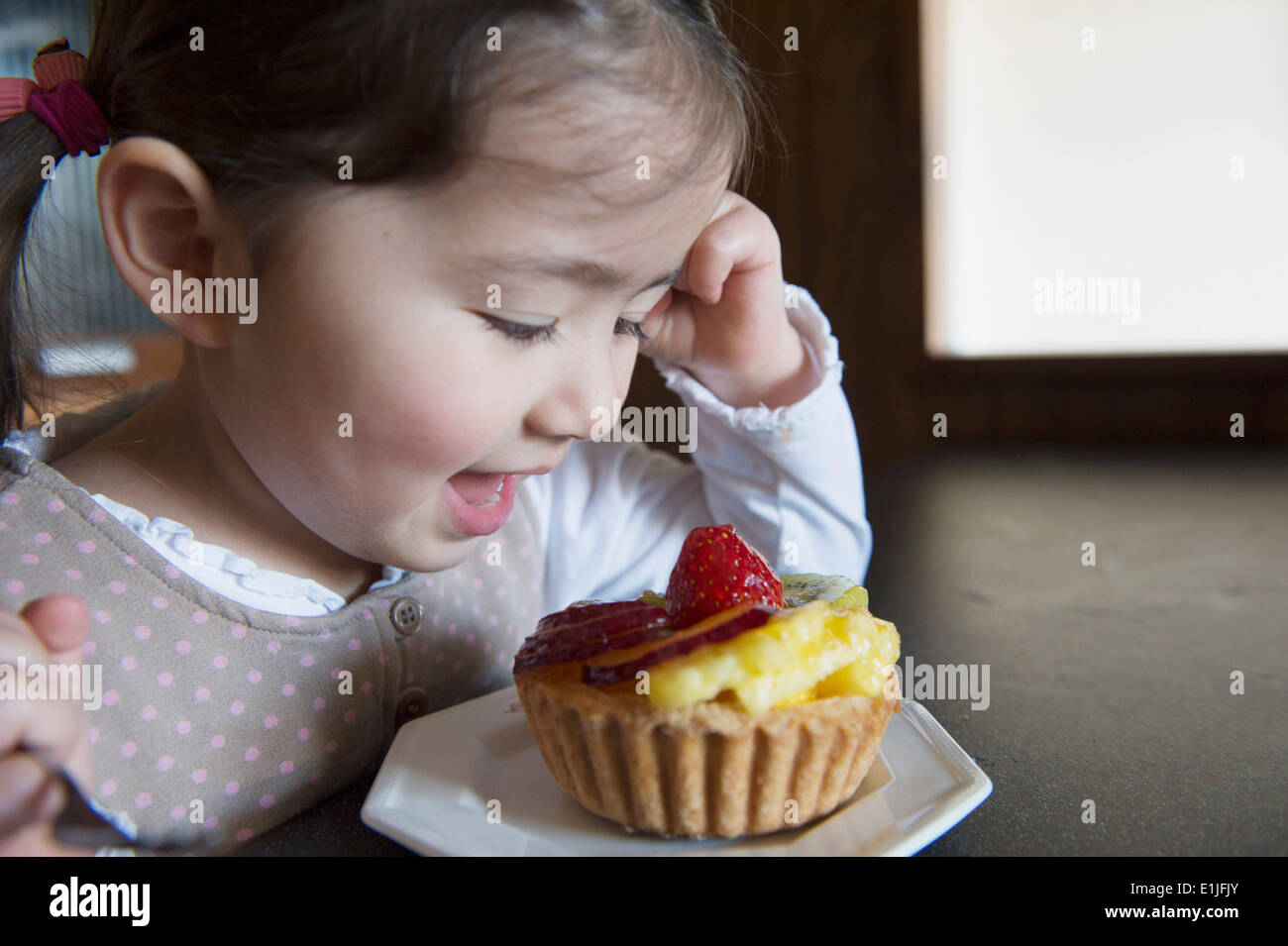 Mädchen glücklich mit ihrer Torte Stockfoto