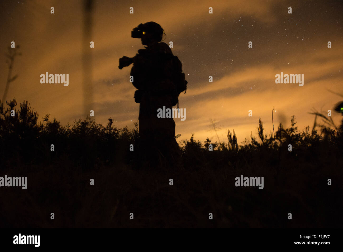 Ein US-Navy-SEAL scannt ein Feld für die simulierten feindlichen Bedrohungen während Betrieb städtischen Korkenzieher als Teil des Emerald Krieger 2013 bei Stockfoto