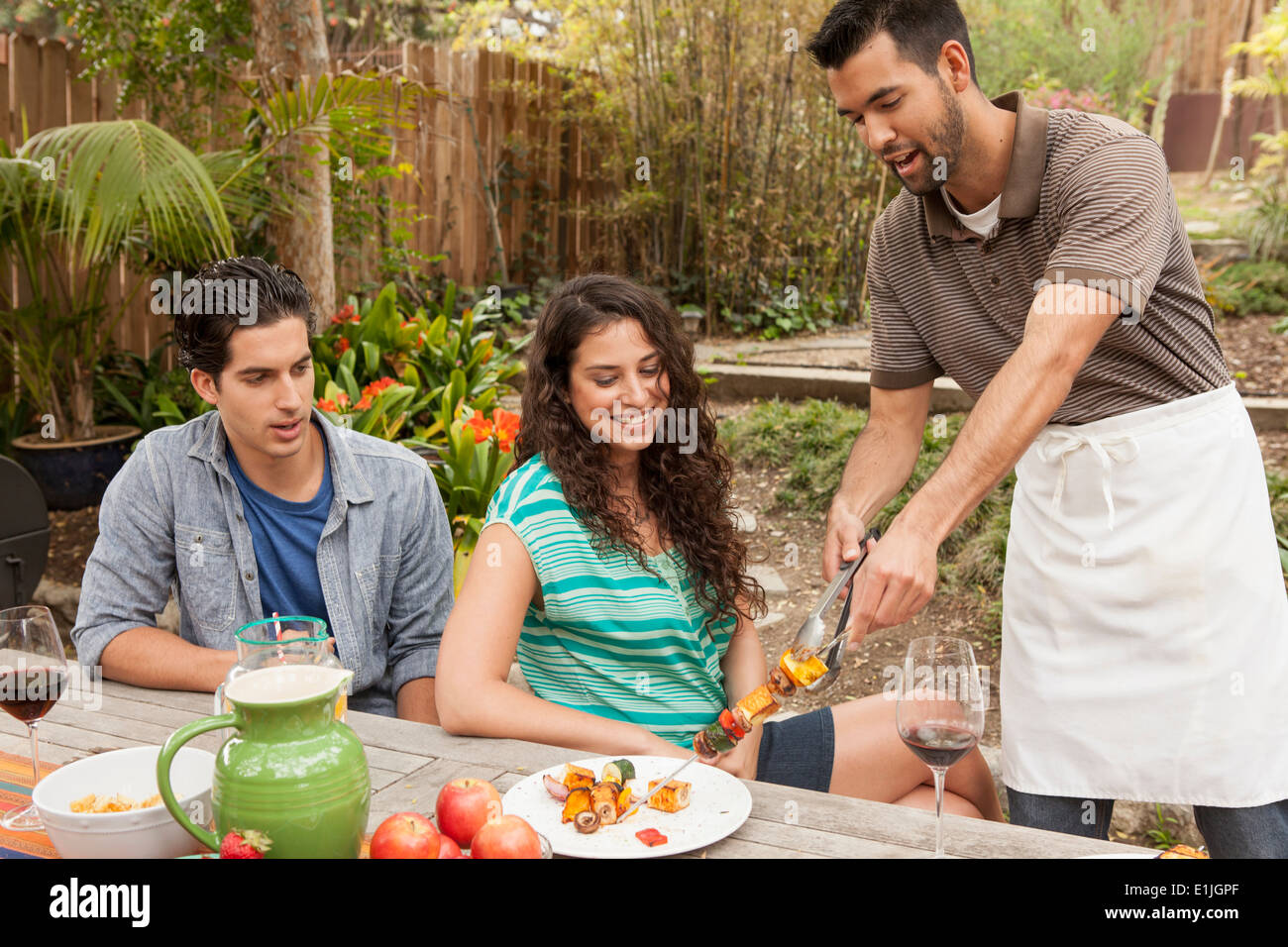 Freunde an Tisch Grill Essen teilen Stockfoto