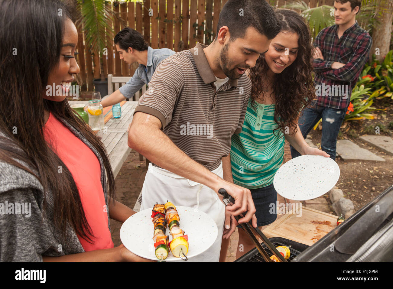 Freunde an Tisch Grill Essen teilen Stockfoto