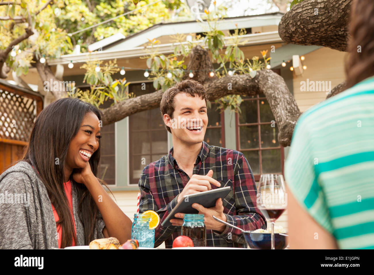 Freunde an Tisch Grill Essen, teilen Menschen mit digital-Tablette Stockfoto