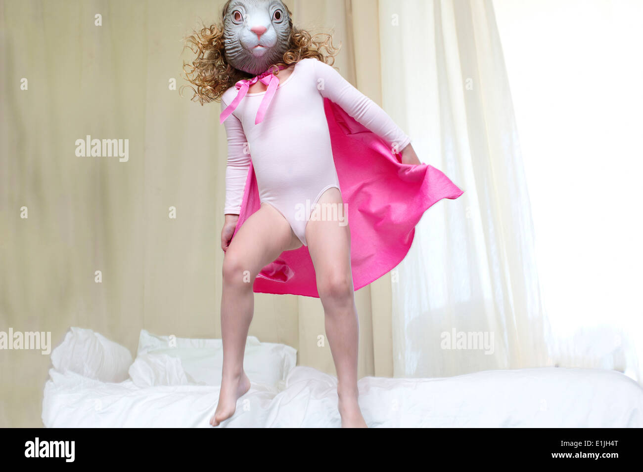 Junges Mädchen verkleidet als Kaninchen Prinzessin tanzen auf Bett Stockfoto