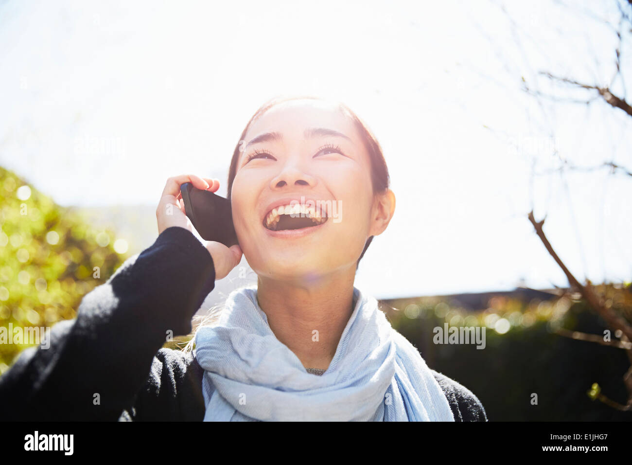 Junge Frau auf Smartphone, lachen Stockfoto
