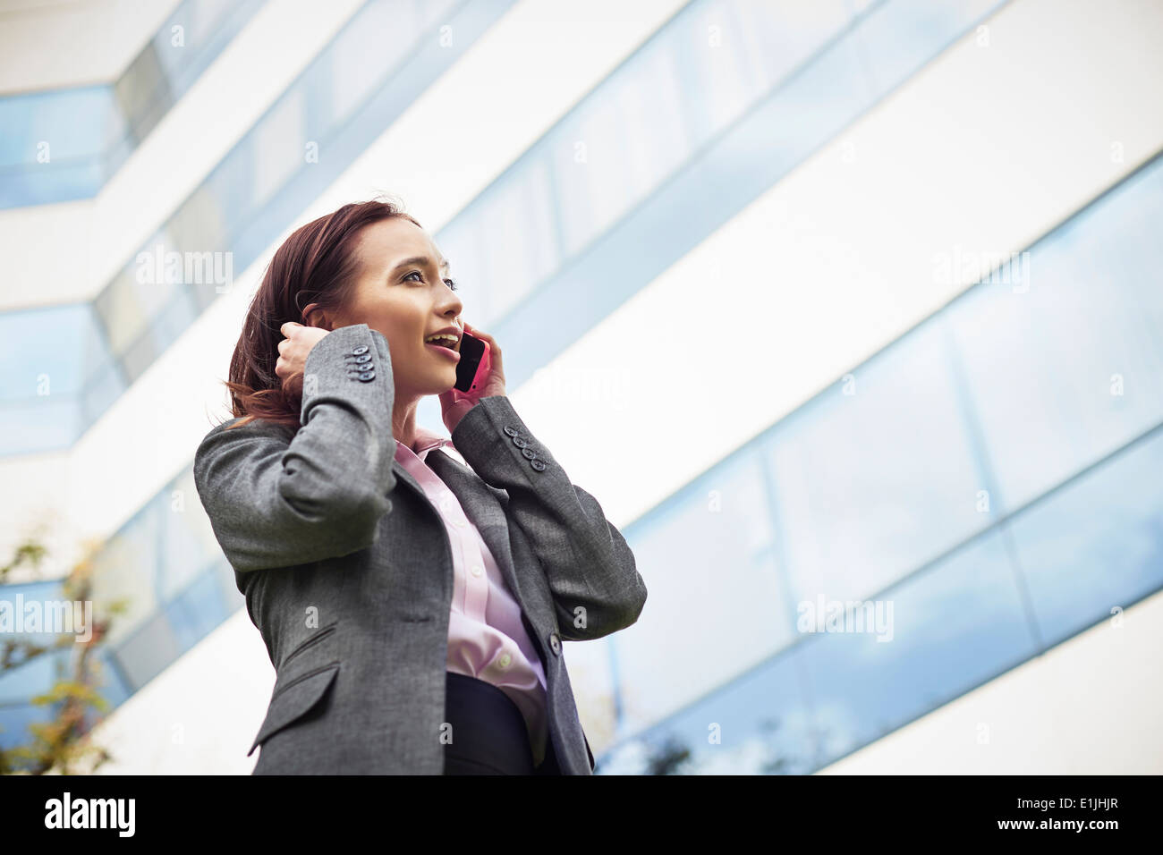 Junge weibliche Unternehmerin am Smartphone außerhalb Büro sprechen Stockfoto