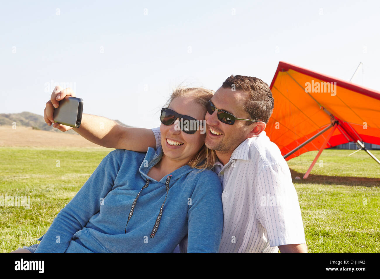 Paar nehmen Selfie, Hängegleiter im Hintergrund Stockfoto