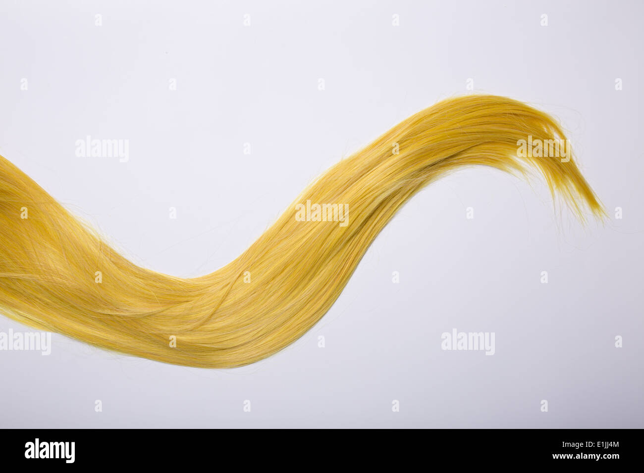 Lange goldblondes Haar, Studio gedreht auf grauem Hintergrund Stockfoto