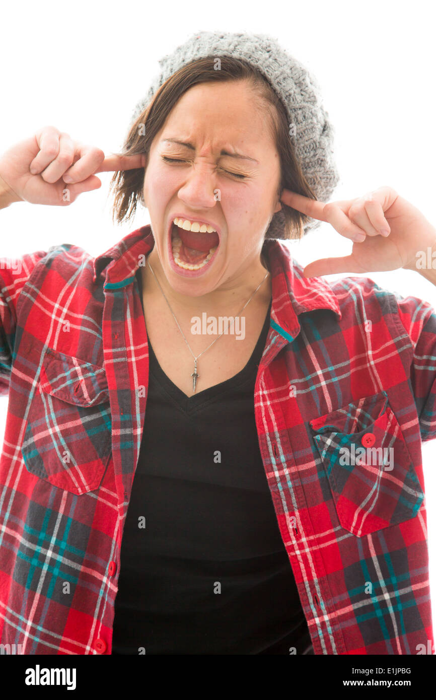 Junge Frau mit den Fingern in den Ohren schreien Stockfoto