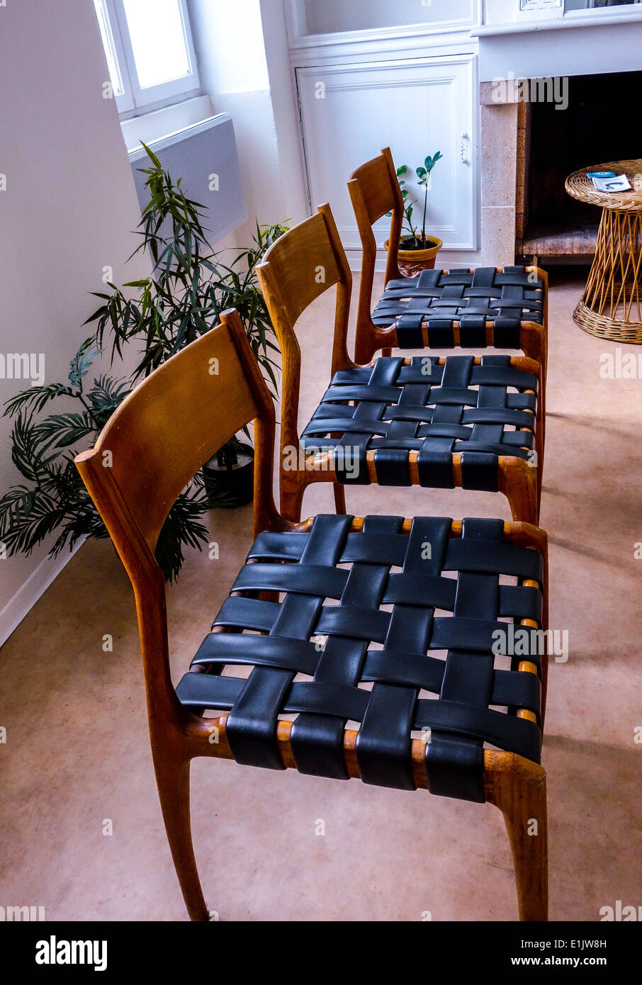 Drei typische Stühle mit schwarzem Lederriemen und rotem Holz gemacht Stockfoto