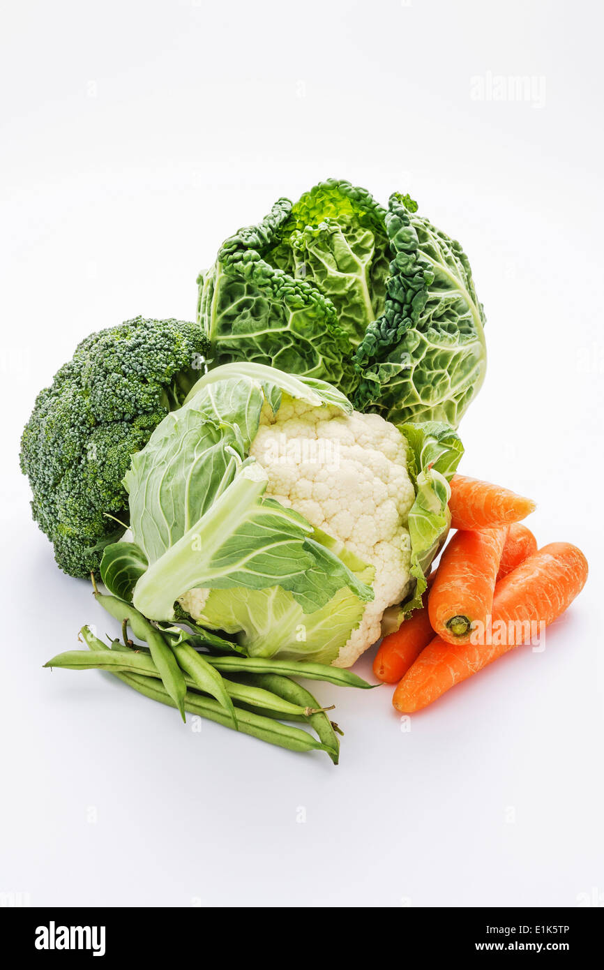 Eine Auswahl an Gemüse auf einem weißen Hintergrund dazu gehören Blumenkohl Brokkoli Karotten grüne Bohnen und Kohl. Stockfoto