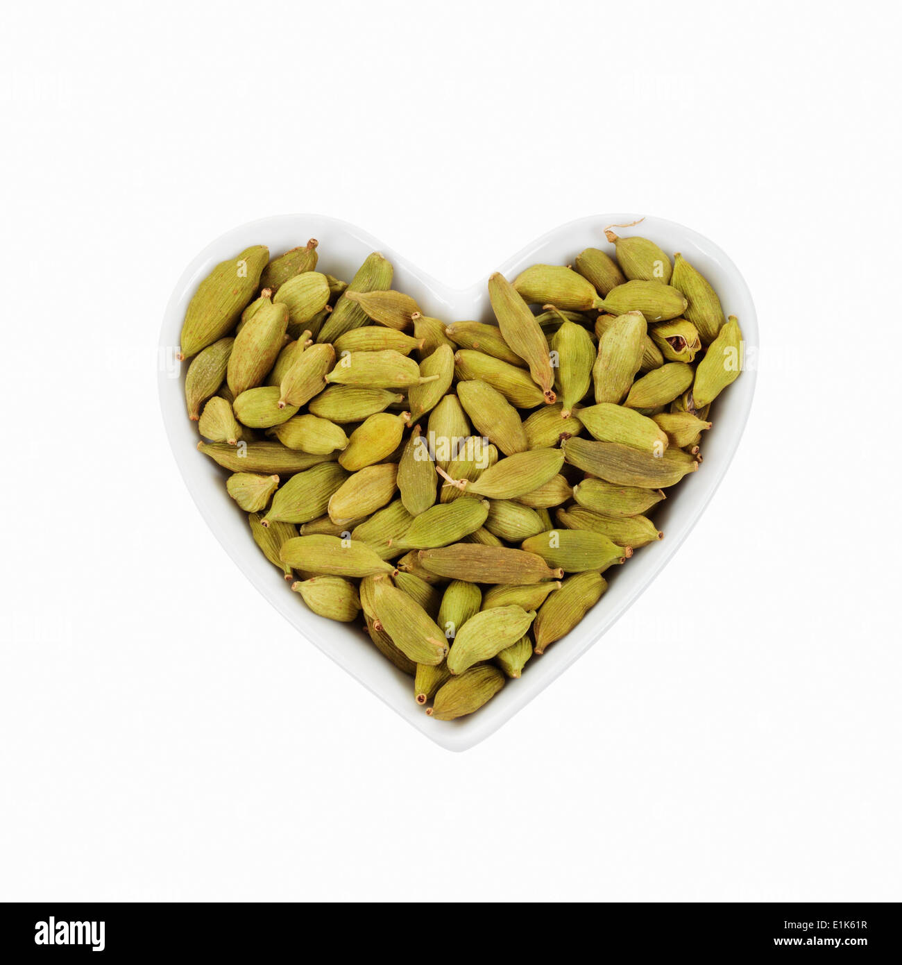 Green Cardamoms in eine herzförmige Schüssel. Stockfoto