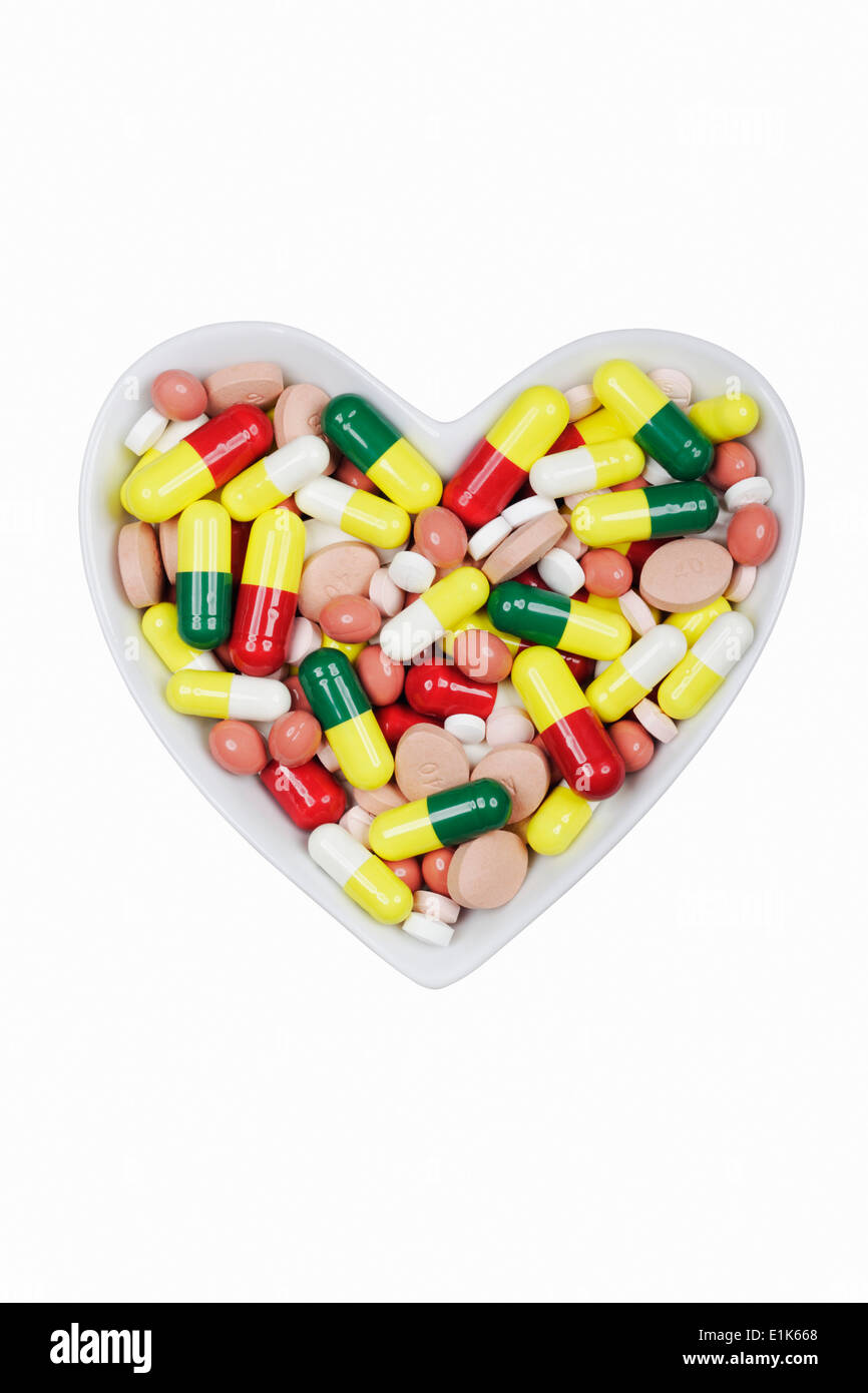 Herzförmige Schüssel mit Generika Pillen/Kapseln. Stockfoto