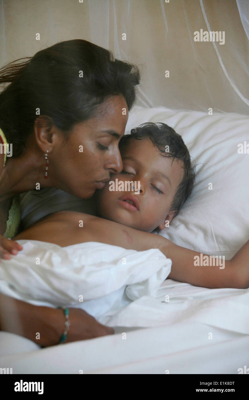 Mutter, küssen ihr schlafendes Kind Stockfoto