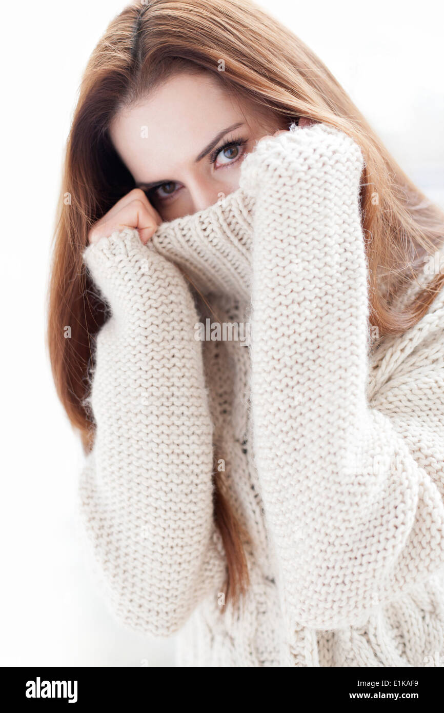 MODEL Release Frau ziehen ihre Pullover über ihr Gesicht. Stockfoto