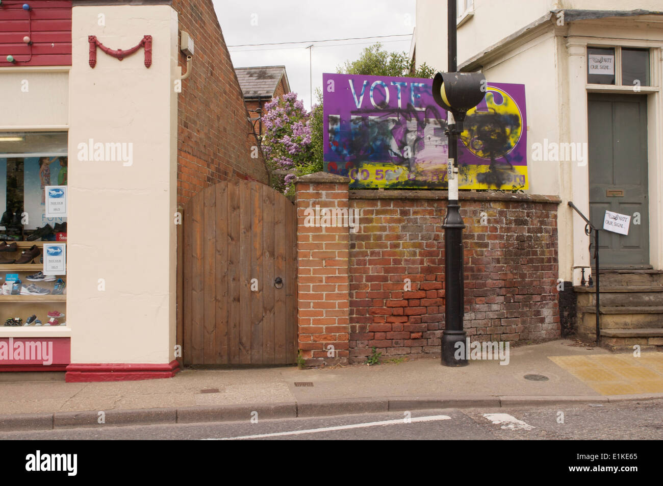 UKIP Wahlplakat verwüstet durch Graffiti in Framlingham, Suffolk, mit Schilder an den Häusern angrenzenden "Nicht unsere Zeichen" zu lesen. Stockfoto