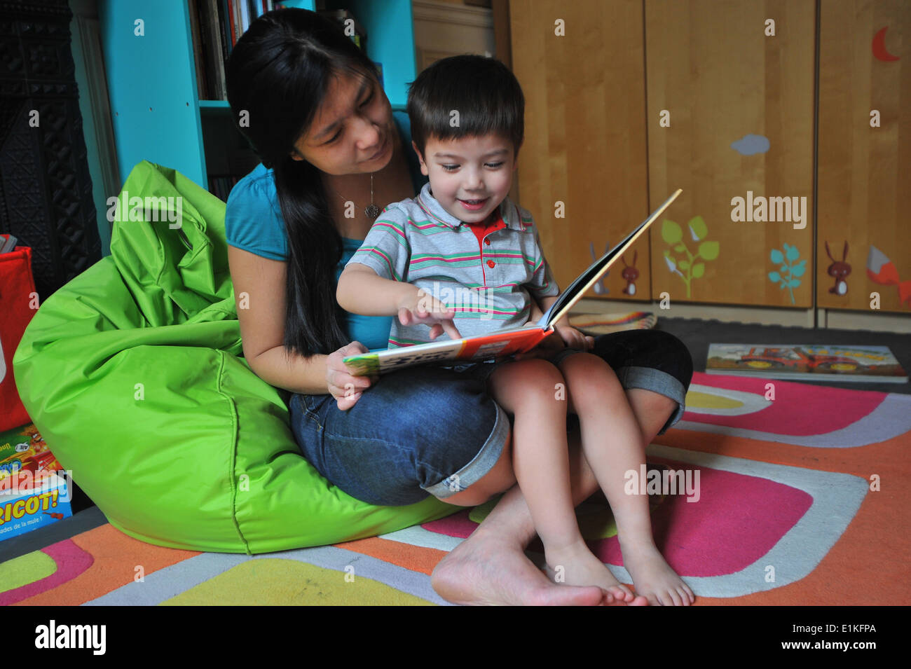 Mutter und Kind ein Buch in dem jungen Schlafzimmer Stockfoto