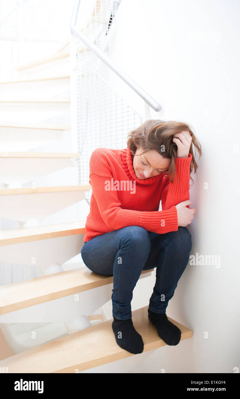 MODEL Release Frau ihre Hand in ihr Haar auf einer Treppe. Stockfoto