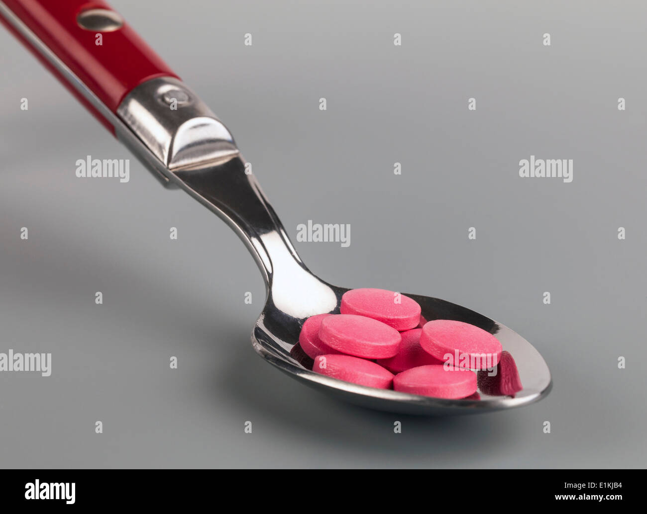 Löffel mit rosa Tabletten medizinischen Abhängigkeit Konzept. Stockfoto
