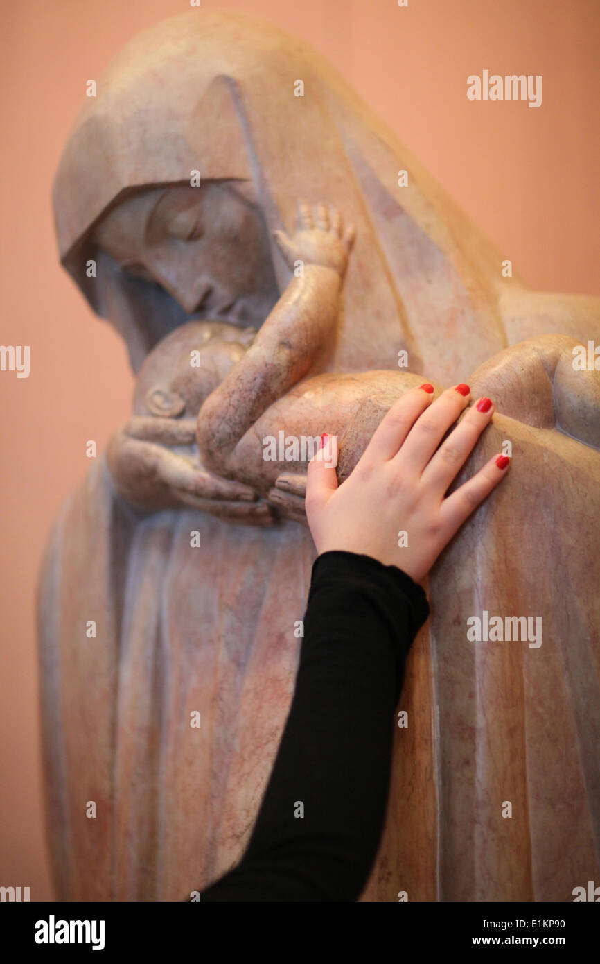 Hand des Gläubigen auf eine Statue der Madonna mit Kind Stockfoto