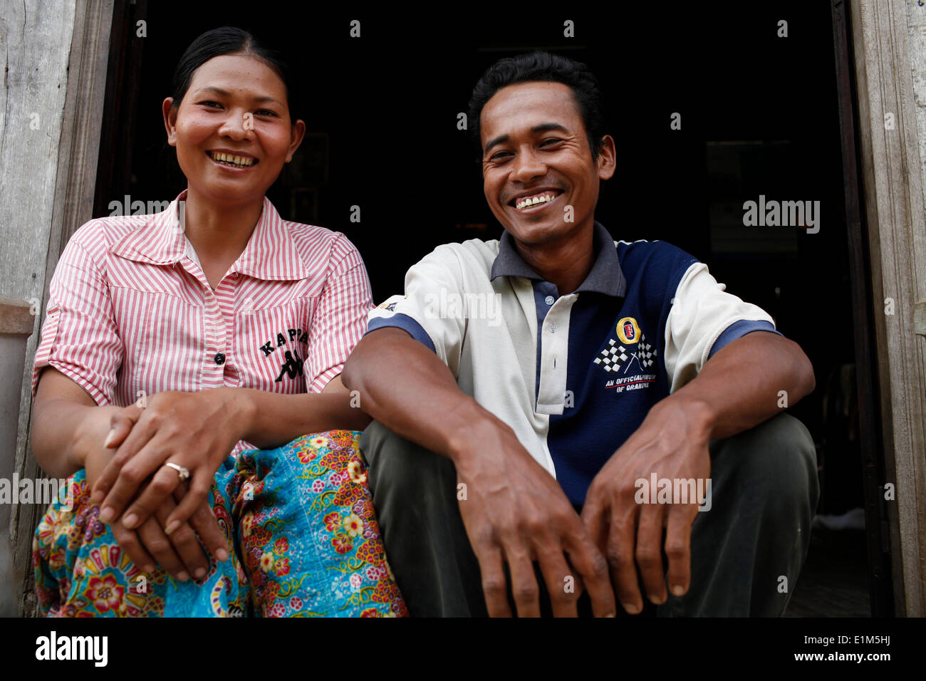 Tron, ein Kunde von HKL Mikrofinanz, vor ihrem Haus mit ihrem Mann bin Stockfoto