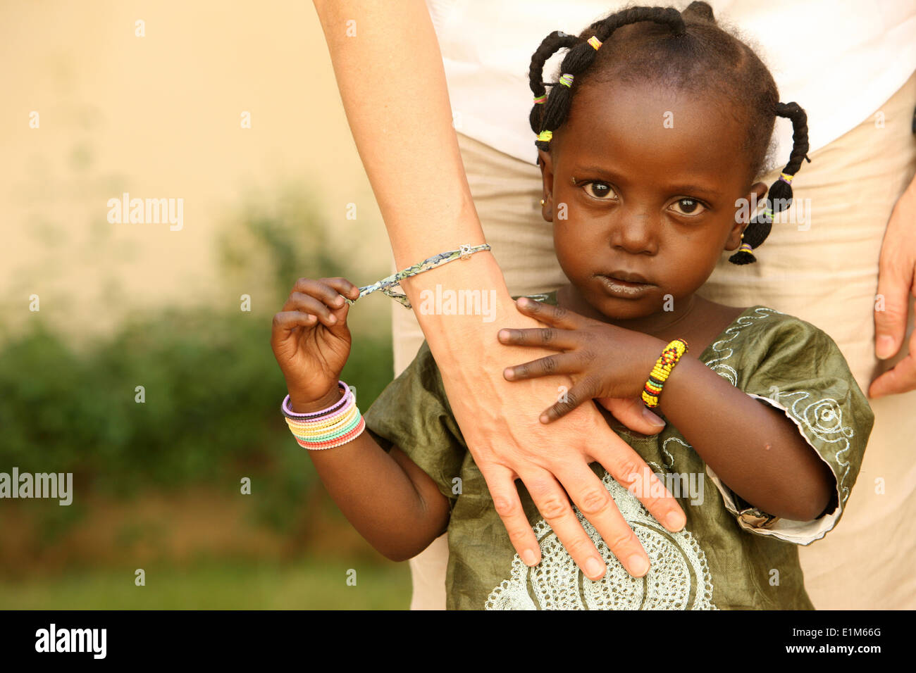Afrikanische Kind hält eine weiße Hand. Stockfoto