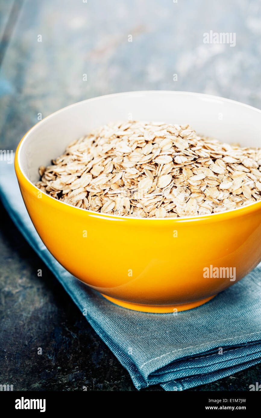 Haferflocken in eine Schüssel auf Holzbrett Stockfoto