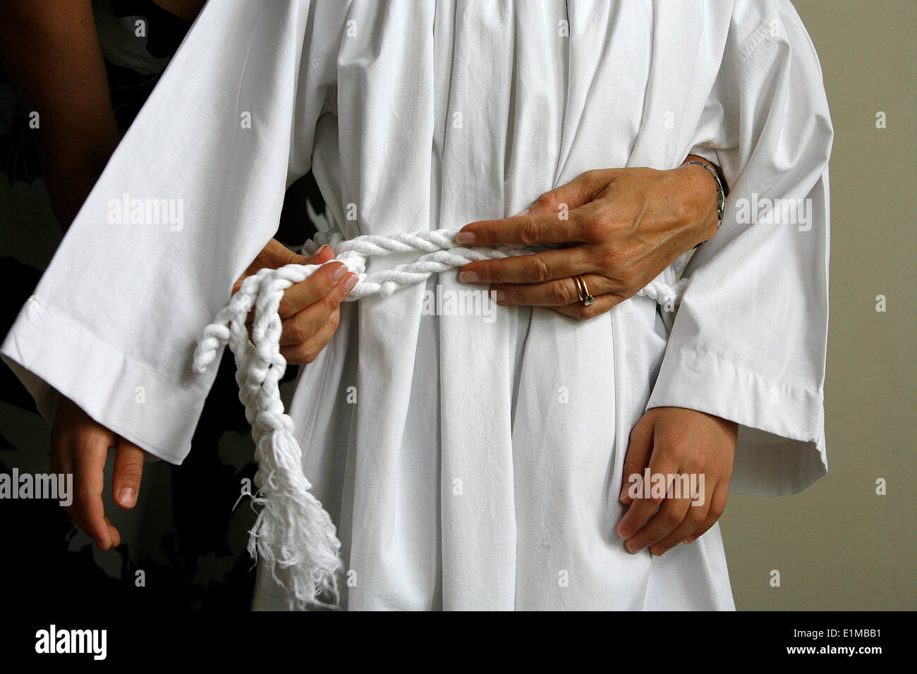 Mutter putzt ihren Sohn für seine erste Heilige Kommunion Stockfoto