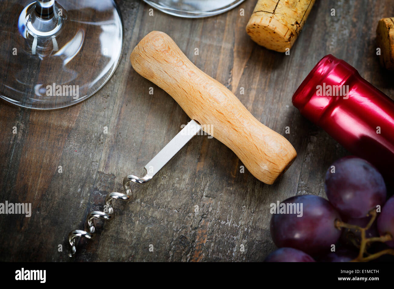 Wein, Trauben, Gläser und Korkenzieher auf hölzernen Hintergrund Stockfoto