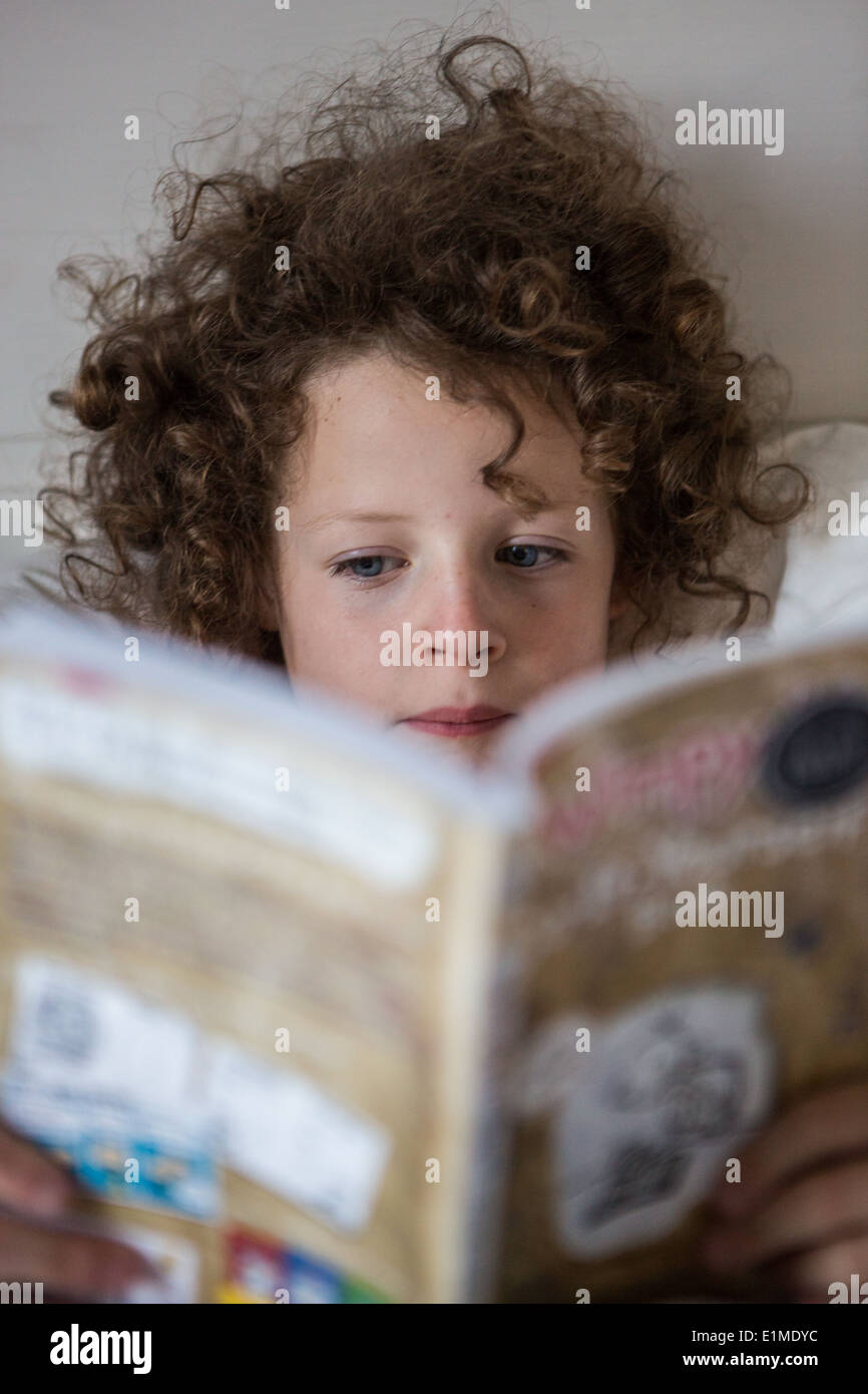 Mädchen-Lesebuch im Bett Stockfoto