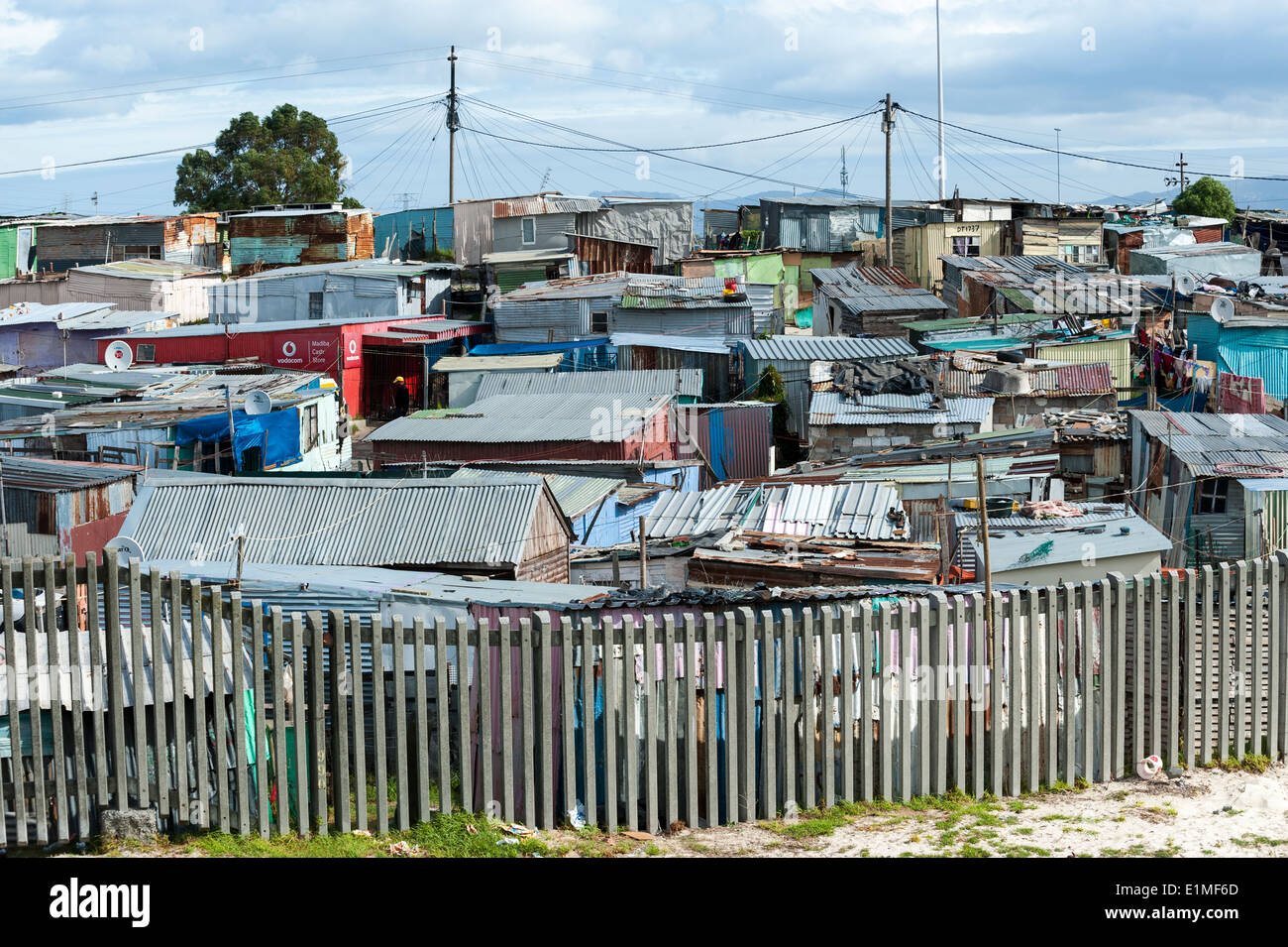 Wellblech Schuppen hinter einem Zaun in Khayelitsha, Kapstadt, Südafrika Stockfoto