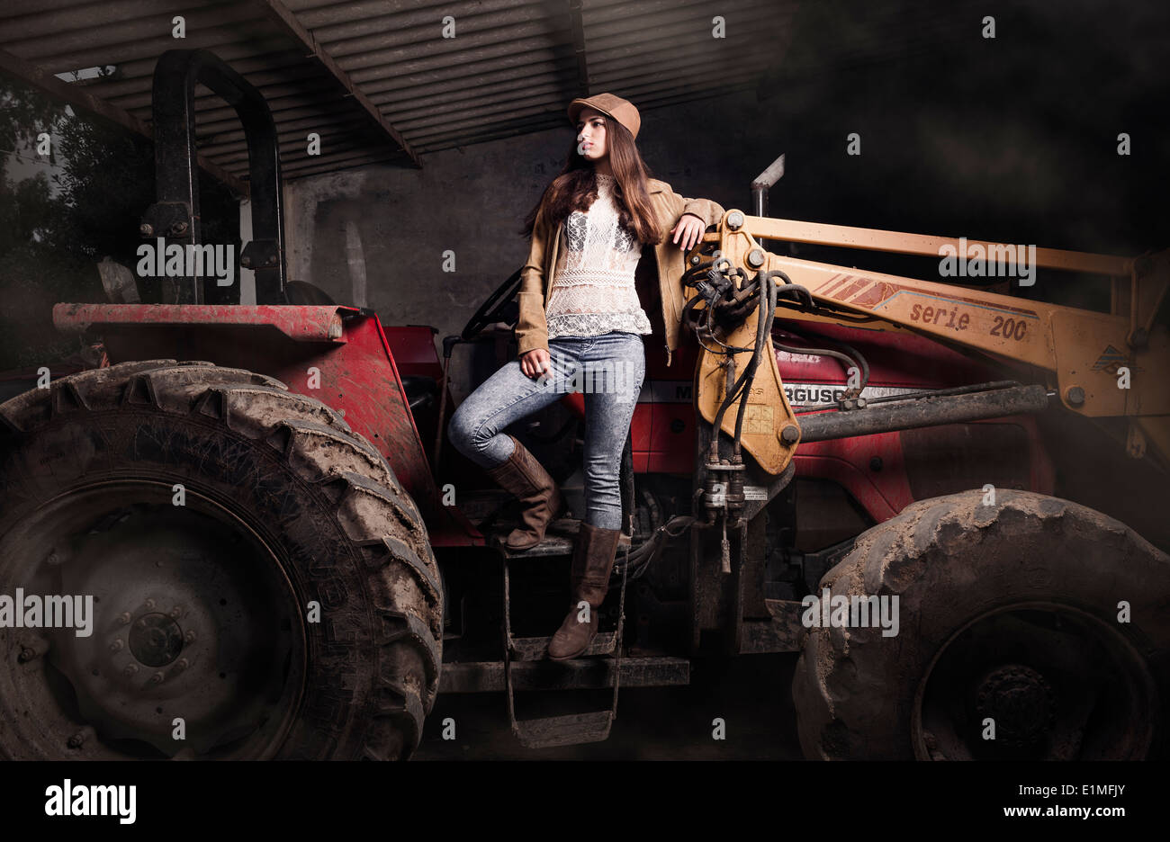 Junge Frau auf einem Traktor. Stockfoto