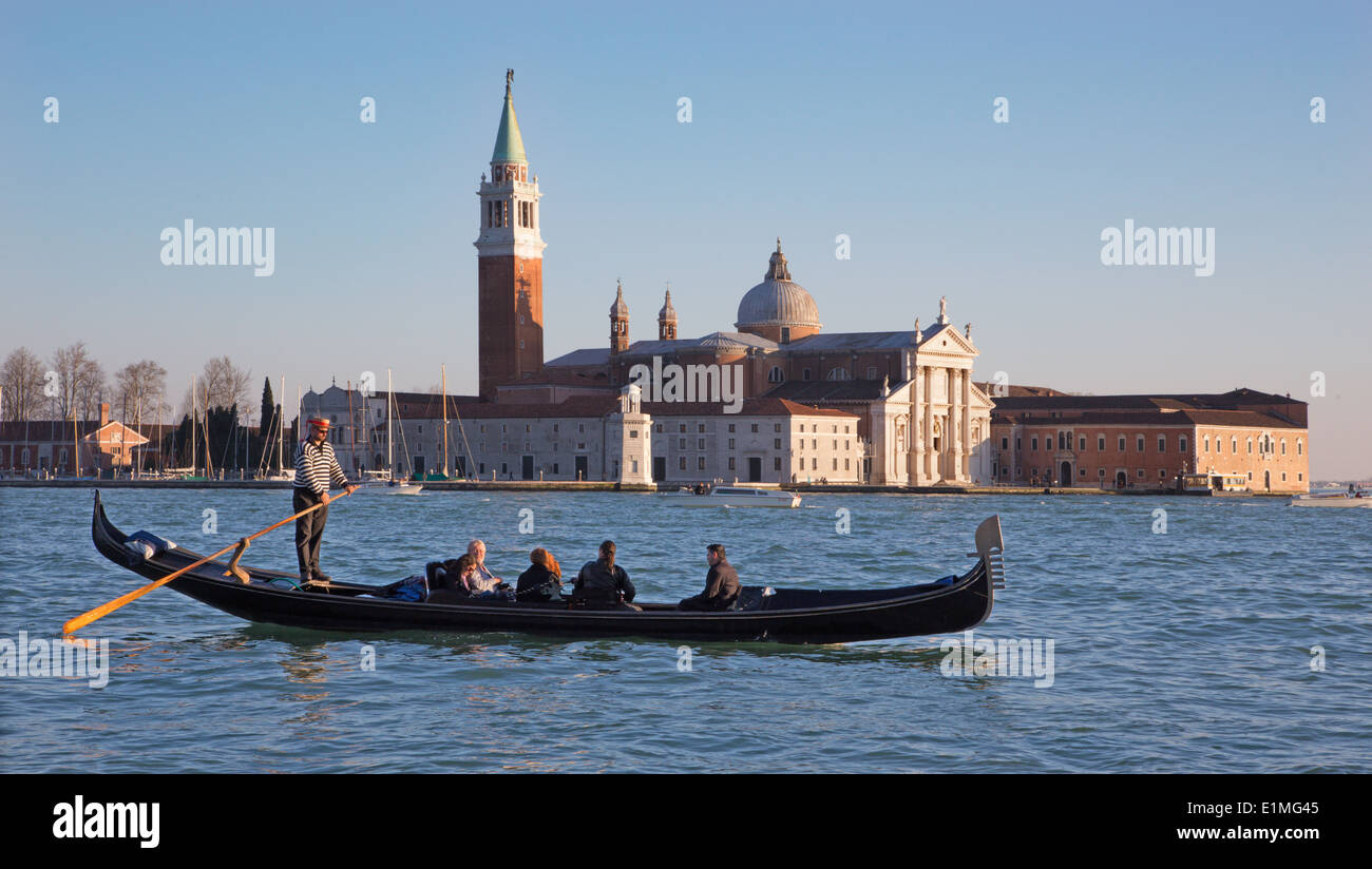 Venedig, Italien - 14. März 2014: Gondoliere auf die Lagune und die Kirche San Giorgio Maggiore im Abendlicht Stockfoto