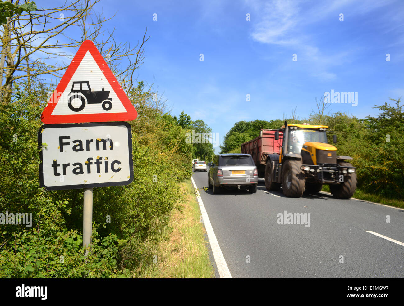 Zugmaschine und Anhänger vorbei Warnsignal für landwirtschaftlichen Verkehr in Road ahead Yorkshire Großbritannien Stockfoto