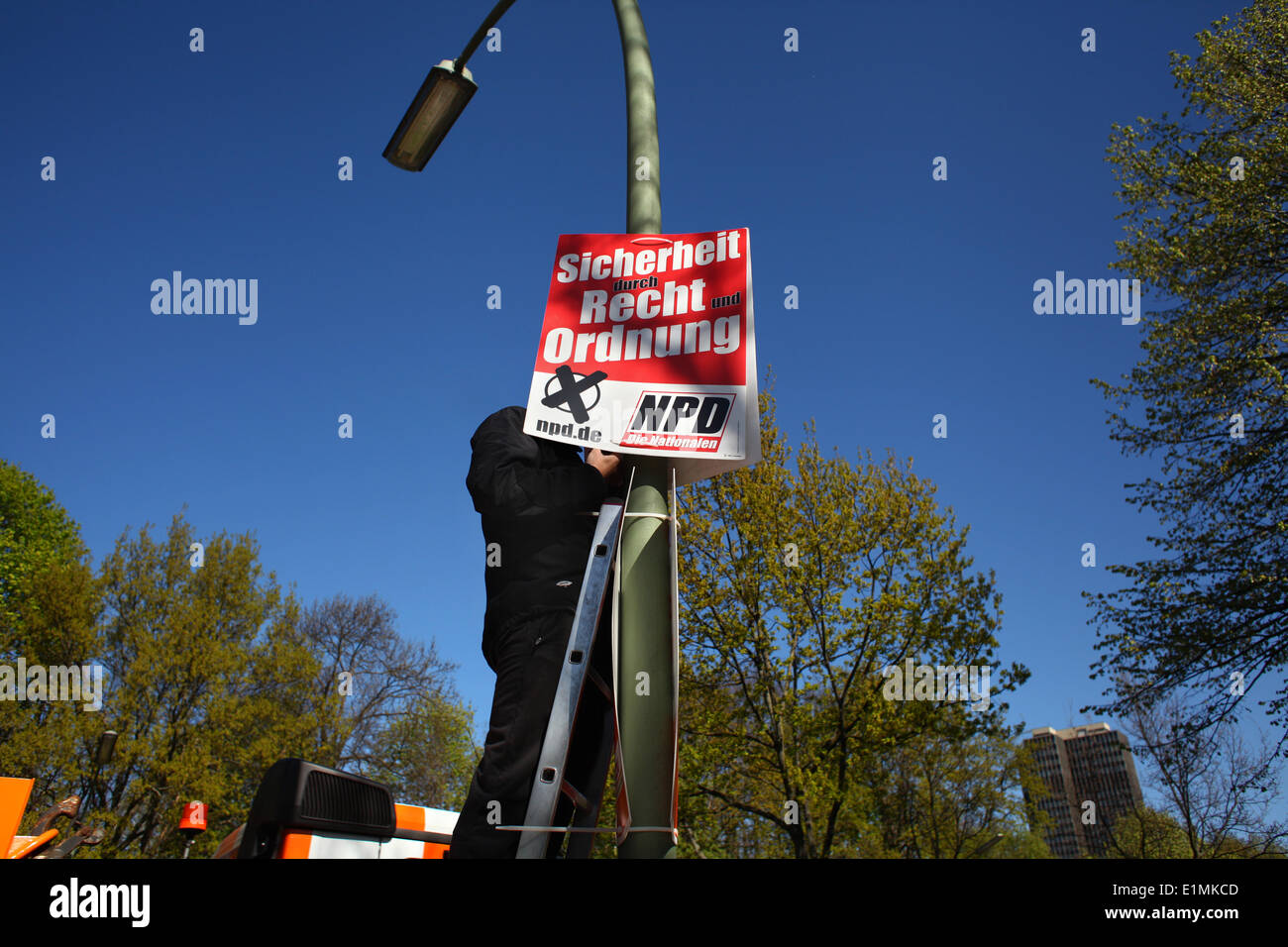 Ein Mann aus Osteuropa aufhängen Wahlplakate für die radikalen deutschen Rightwingers Partei NPD (Deutsch Nationaldemocratic Paty) vor den Wahlen zum Europäischen Parlament am 16. April 2014. Foto: Wolfram Steinberg dpa Stockfoto