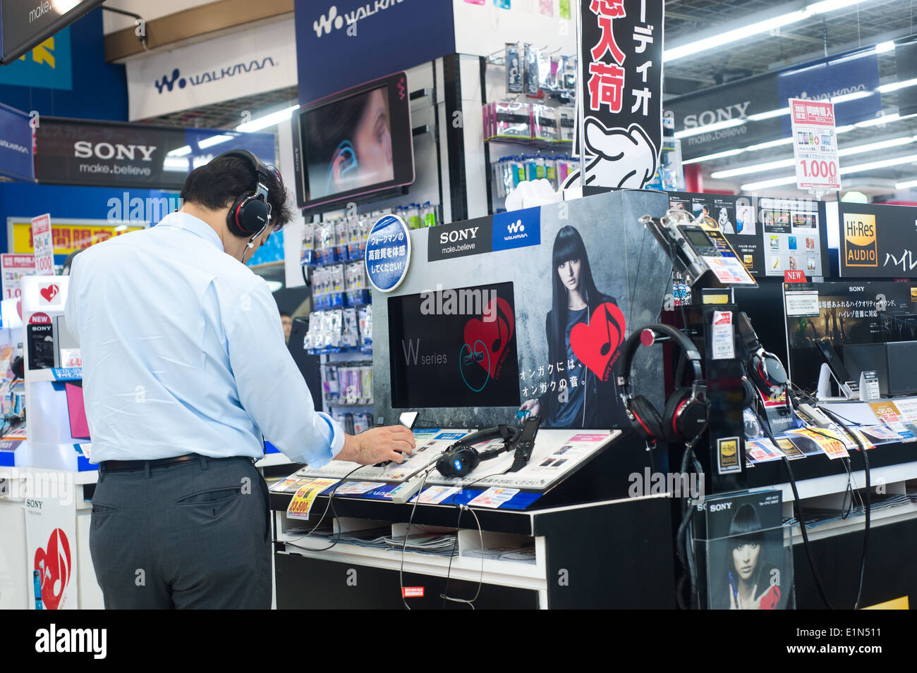 Tokyo Japan 2014 - Mann versucht Kopfhörer in einem Elektronikfachgeschäft kaufen Stockfoto