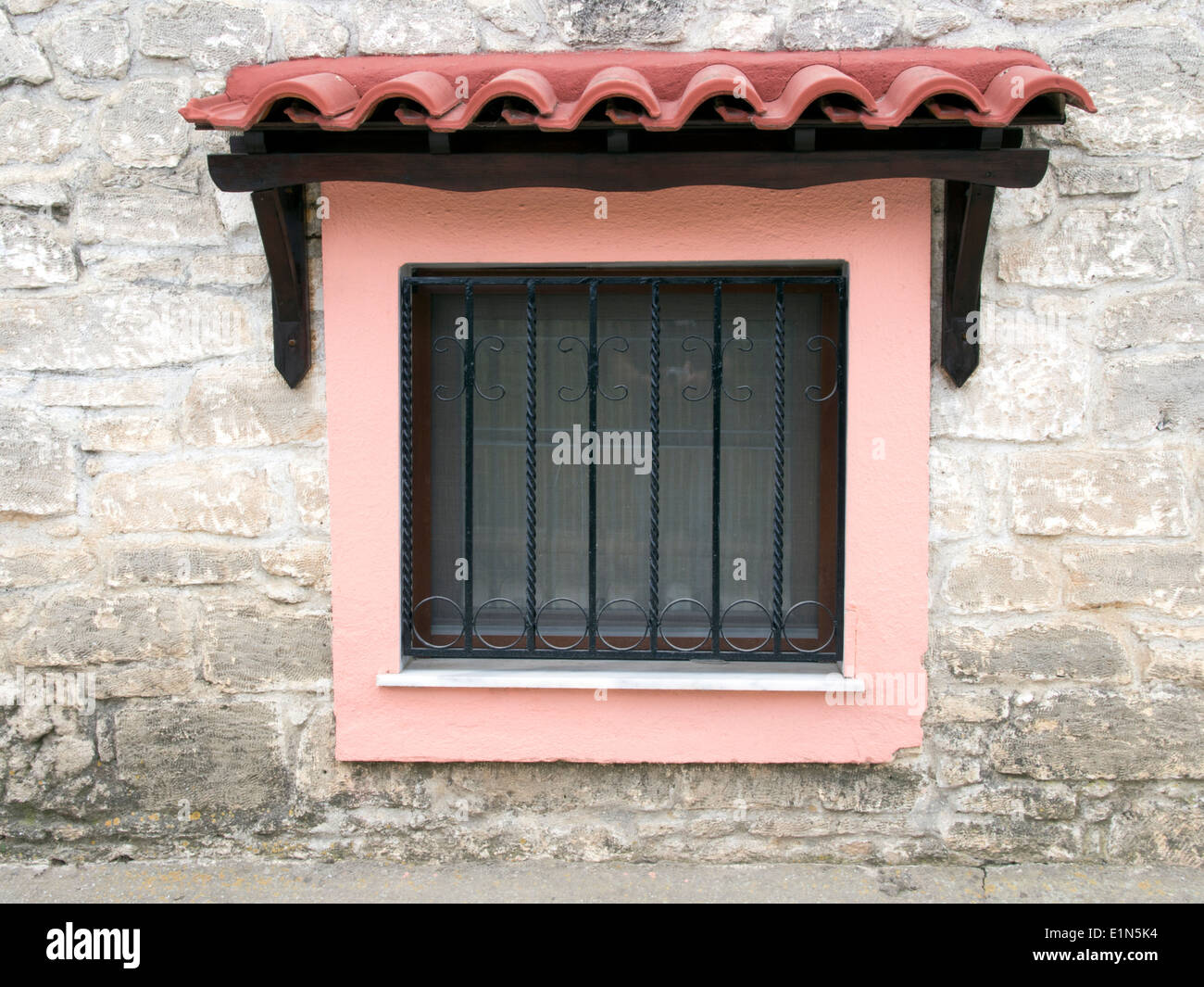 Farbenfrohe Fensterrahmen inmitten einer Steinmauer Stockfoto