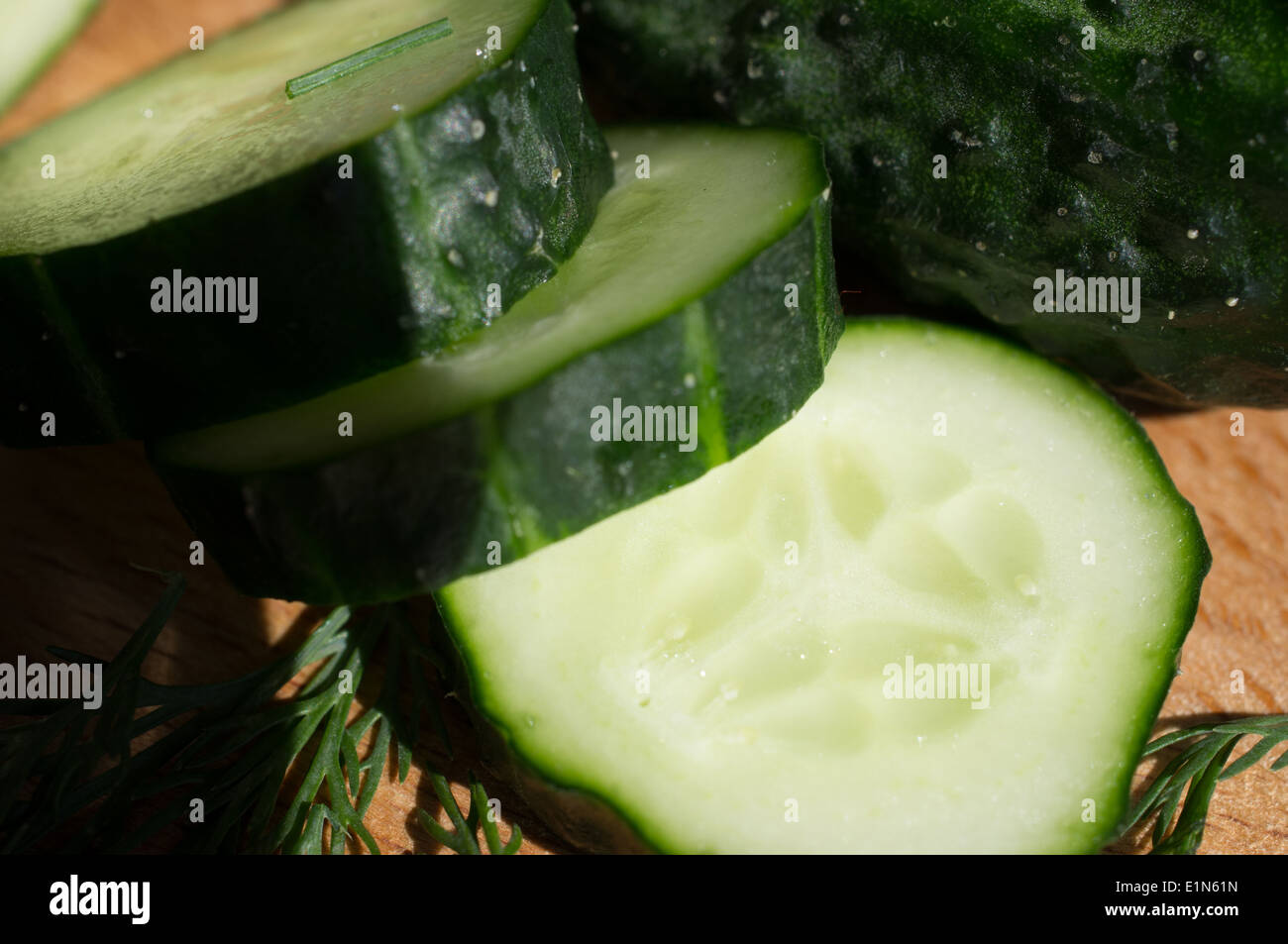 Gurken schneiden Messer auf einem Holzbrett und Dill. Stockfoto