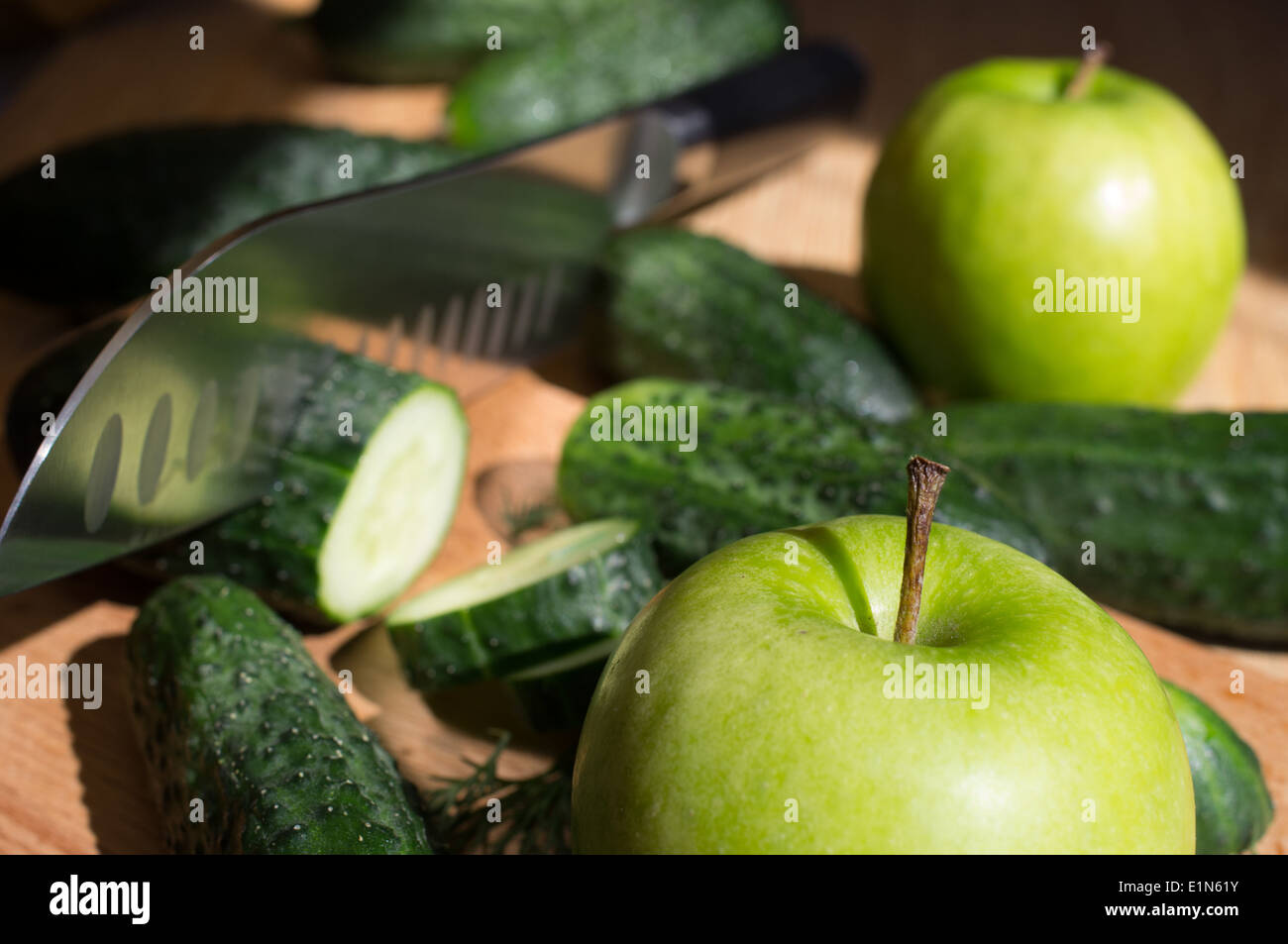 Gurken schneiden Messer auf ein Holzbrett und Dill und Apple. Stockfoto