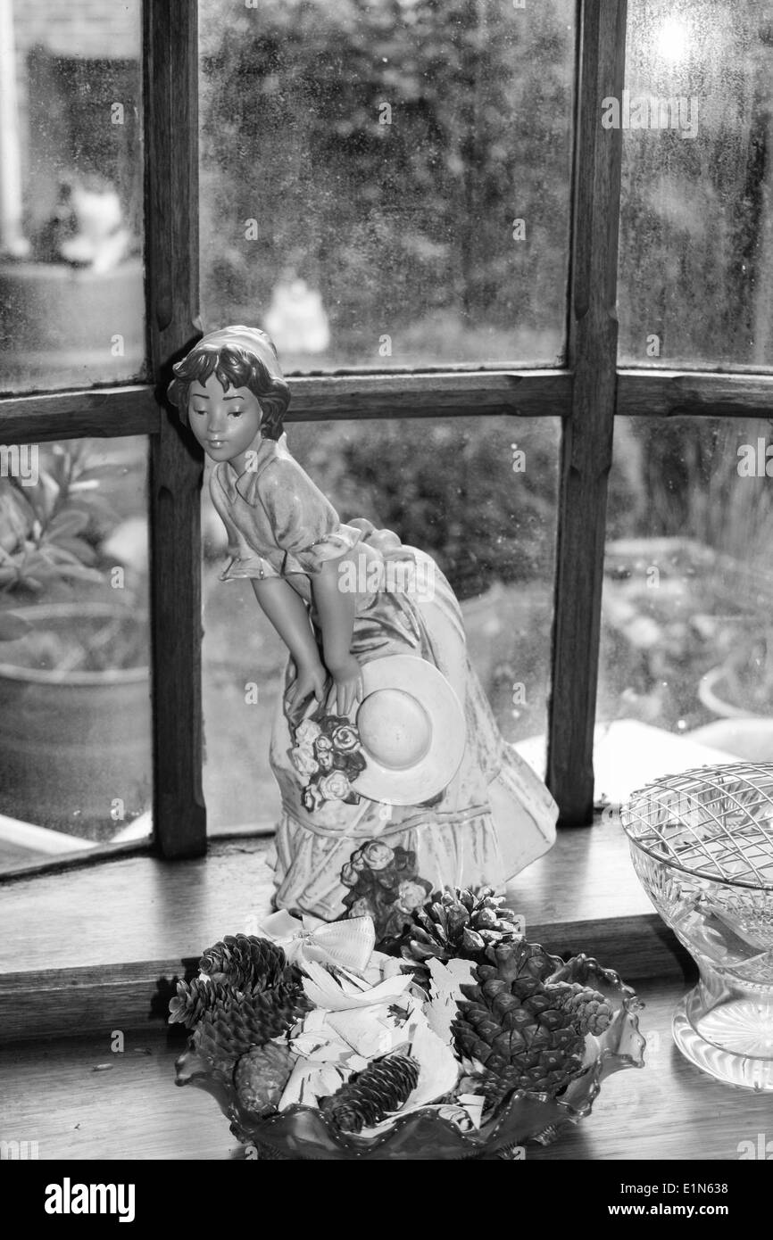 Lladro Dame mit Hut im Fenster im schwarzen und weißen Farbe Stockfoto