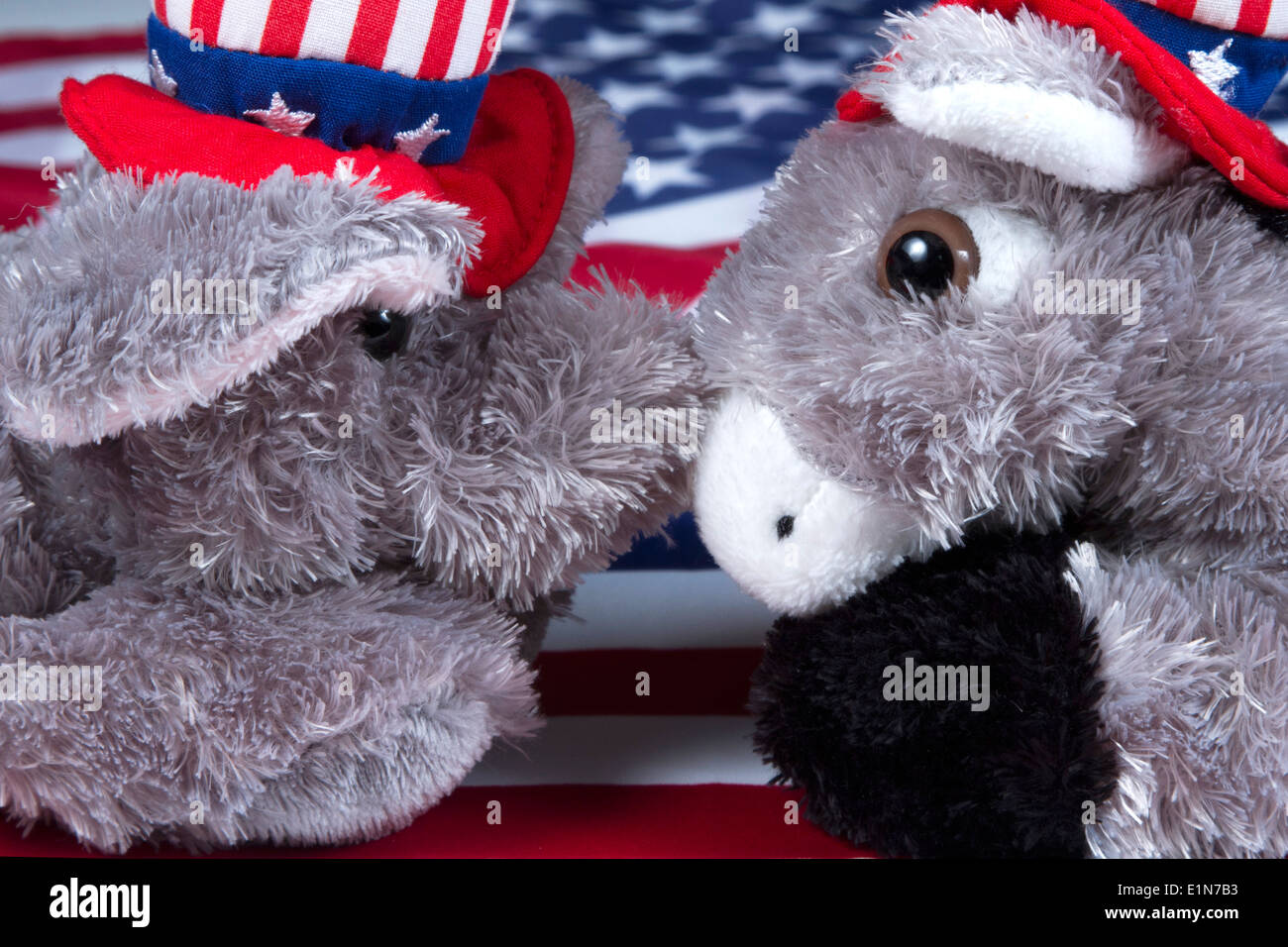 Elefant der Republikaner und Demokraten Esel Spielzeug Maskottchen Nase an Nase vor einer amerikanischen Flagge Stockfoto