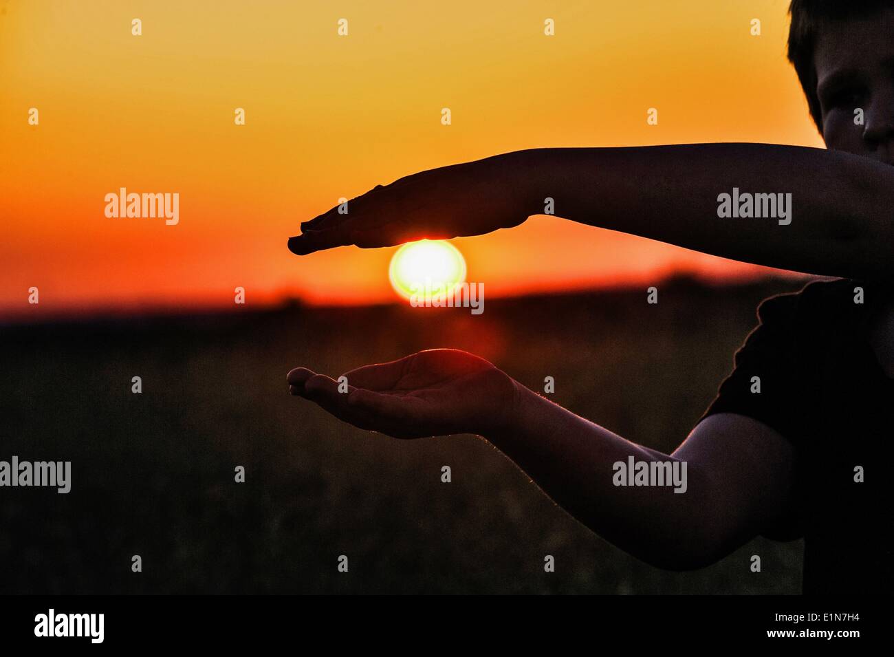 Berlin, Deutschland. 6. Juni 2014. Ein Junge den Rahmen für der untergehende Sonne mit seinen Händen in Berlin, Deutschland, 6. Juni 2014. Foto: PAUL ZINKEN/Dpa/Alamy Live News Stockfoto