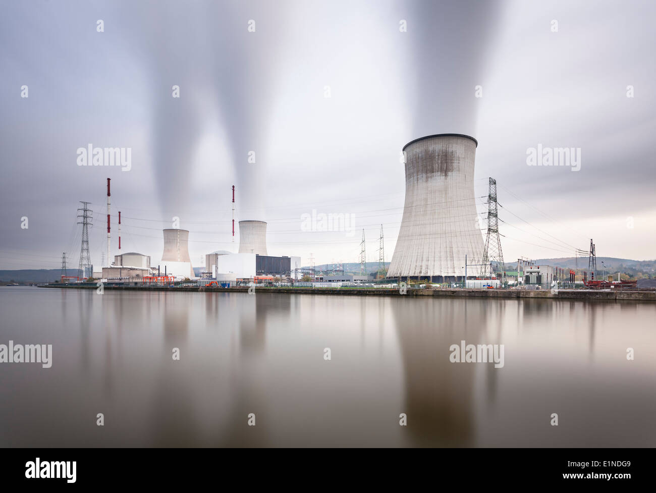 Langzeitbelichtung Schuss von einem großen Kernkraftwerk durch einen Fluss an einem grauen Tag Stockfoto