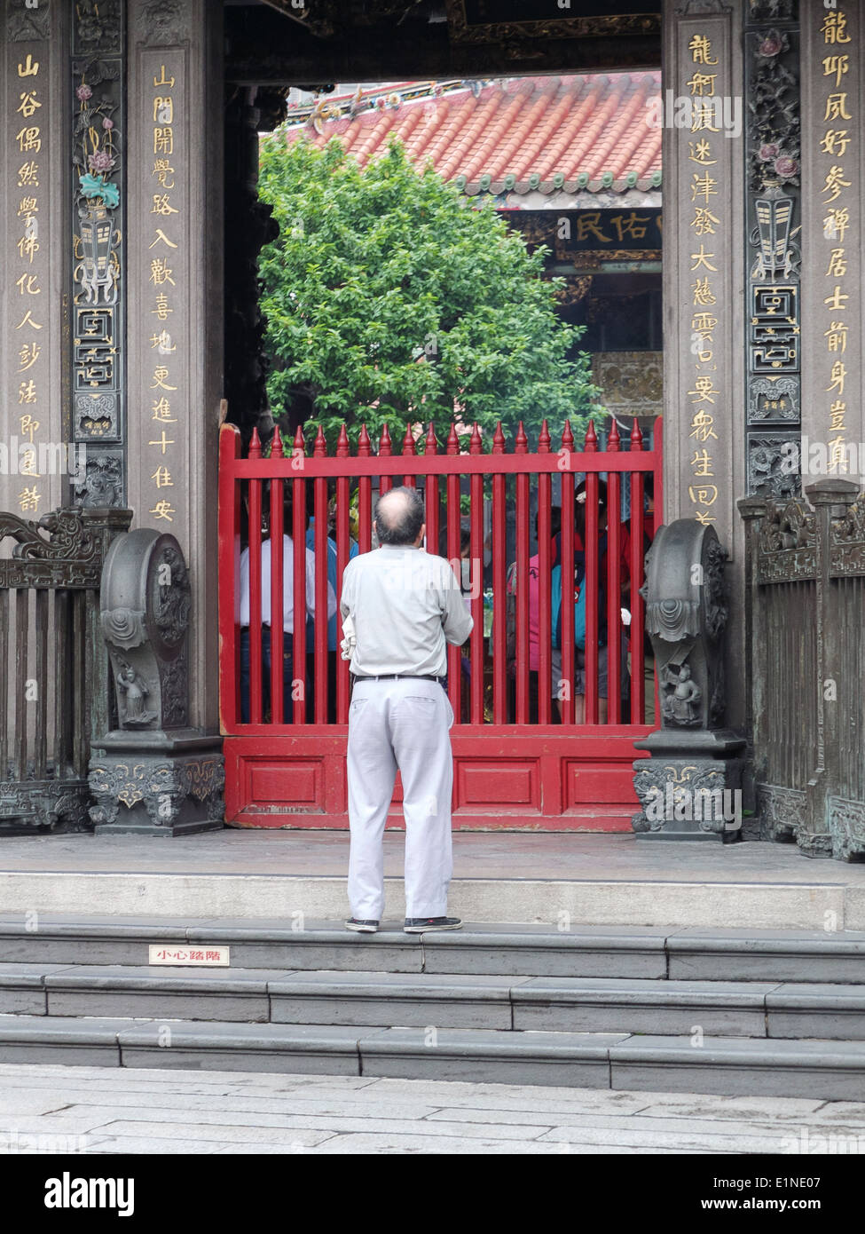 Mann zahlt Respekt an der Pforte der Longshan Tempel, der älteste unter den buddhistischen Tempel Taipei, Taiwan. Stockfoto