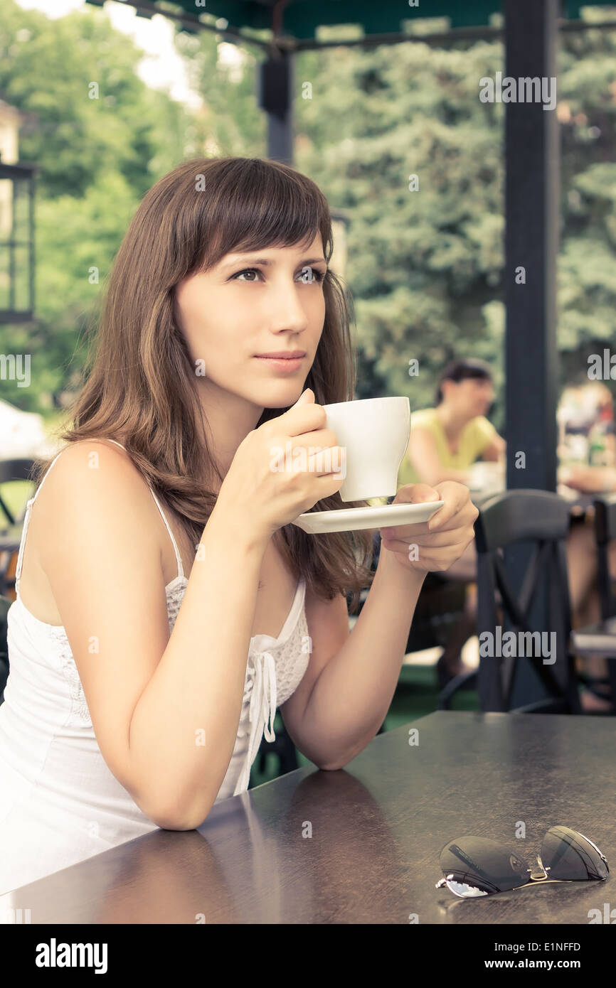 Porträt der jungen Frau im Café sitzen. Träumen Mädchen mit Tasse Kaffee. Warme Farbe getönt Bild Stockfoto